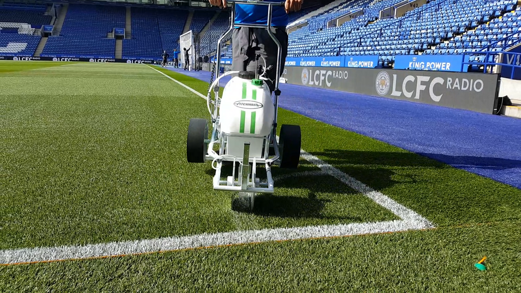 Hybrid mentre traccia l'angolo di un campo da calcio, mostrando come sollevare e spostare il traccialinee